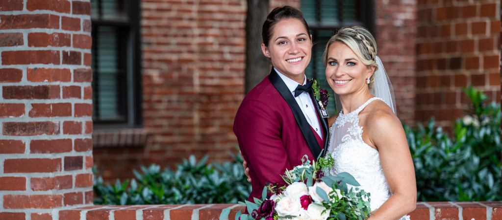 Two brides posing on their wedding day. This is for the article called how to pick a wedding date