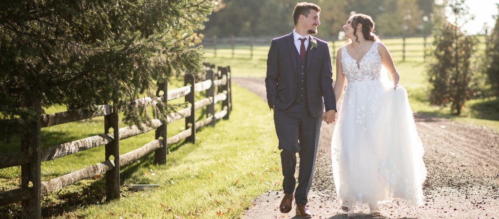 A bride and groom walking on a dirt road. This is for the article called how to pick a wedding date